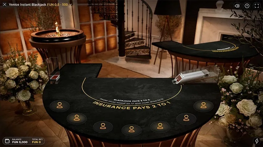 Venice Instant Blackjack table in the Venice studio with seven empty seats, a spiral staircase and a roulette wheel behind